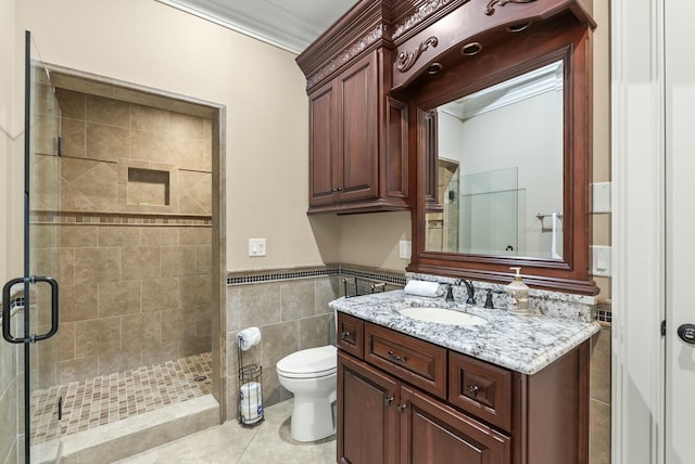 bathroom featuring a shower with shower door, tile walls, ornamental molding, vanity, and tile patterned flooring