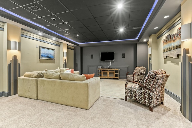 carpeted home theater room featuring a paneled ceiling and a tray ceiling