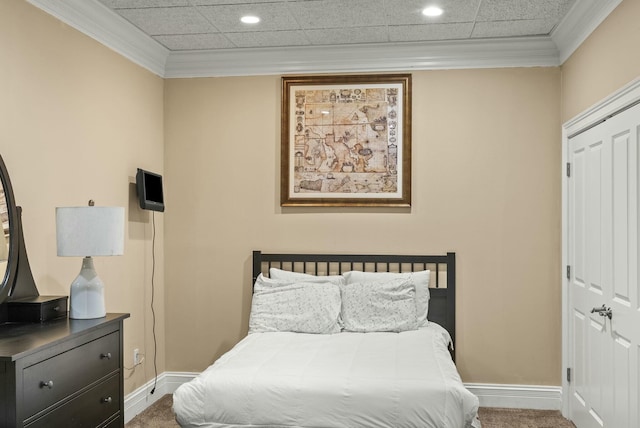 bedroom with crown molding, carpet floors, and a closet