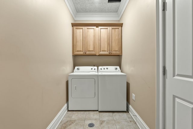 laundry area featuring cabinets, ornamental molding, light tile patterned floors, and washing machine and clothes dryer