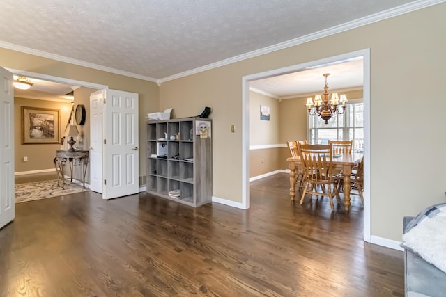 interior space featuring a chandelier, ornamental molding, a textured ceiling, and dark wood-type flooring