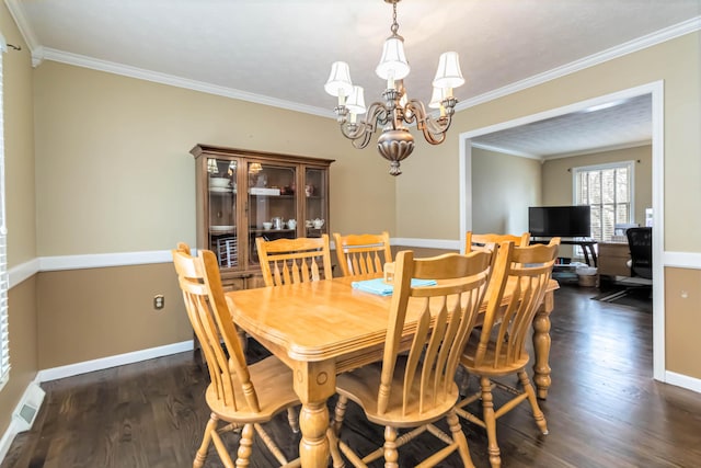 dining room with an inviting chandelier, crown molding, and dark hardwood / wood-style floors