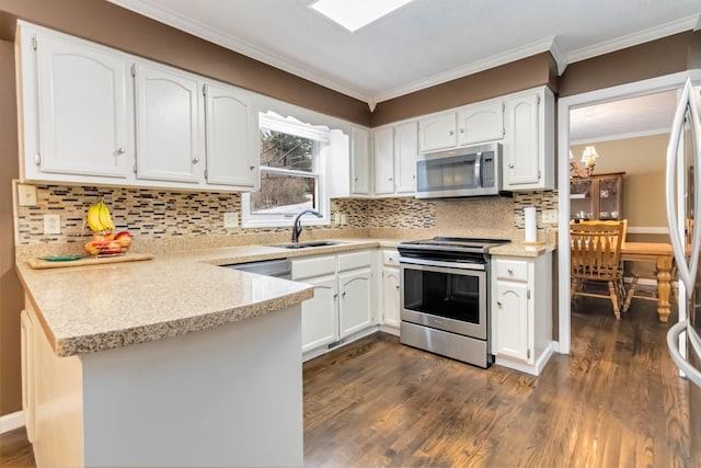 kitchen with sink, crown molding, appliances with stainless steel finishes, white cabinets, and kitchen peninsula