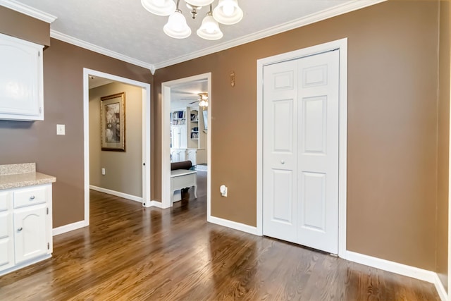 unfurnished dining area with an inviting chandelier, crown molding, and hardwood / wood-style floors