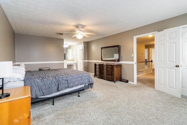 carpeted bedroom with ceiling fan and ensuite bath