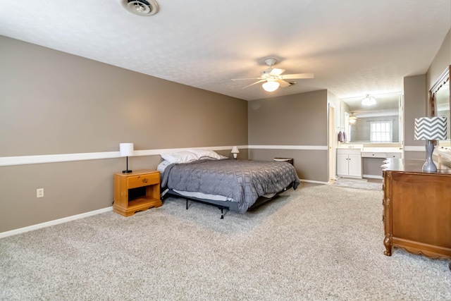 bedroom featuring connected bathroom, light colored carpet, and ceiling fan