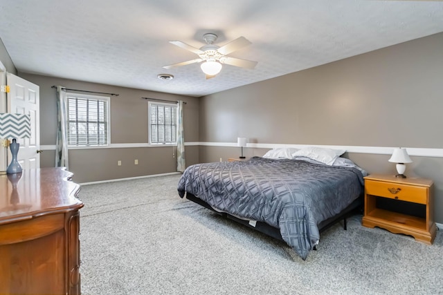 bedroom featuring a textured ceiling, carpet floors, and ceiling fan