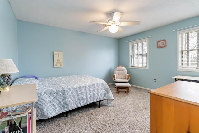 carpeted bedroom featuring multiple windows and ceiling fan