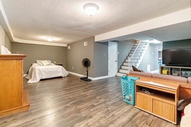 bedroom featuring wood-type flooring and a textured ceiling