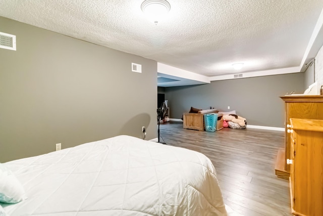 bedroom with hardwood / wood-style floors and a textured ceiling