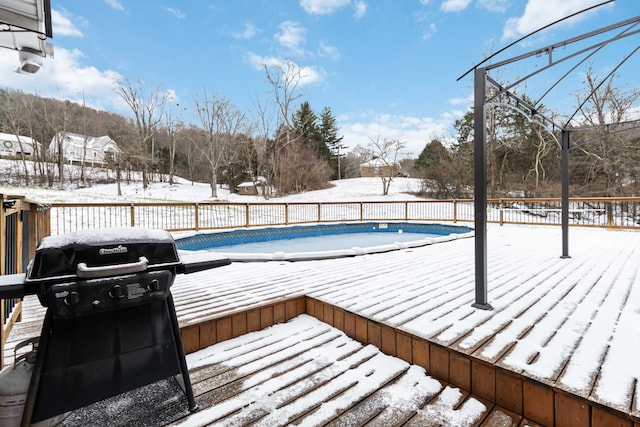 snow covered pool with a deck and grilling area