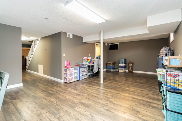 basement featuring hardwood / wood-style floors and a textured ceiling