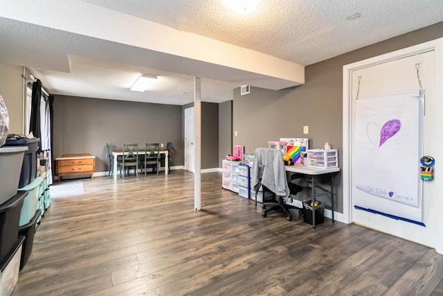 playroom featuring dark hardwood / wood-style flooring and a textured ceiling