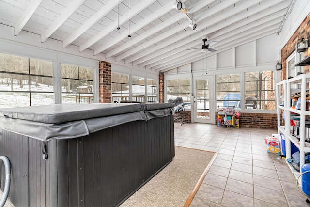 sunroom featuring ceiling fan, wood ceiling, lofted ceiling with beams, and a healthy amount of sunlight