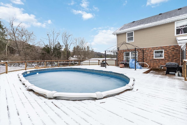 snow covered pool with a deck and grilling area