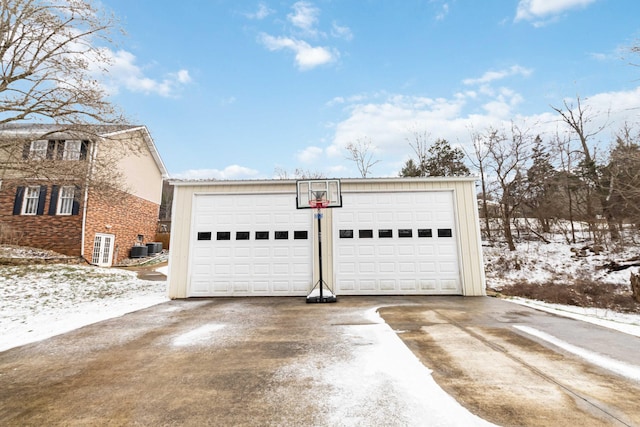 snow covered garage with cooling unit