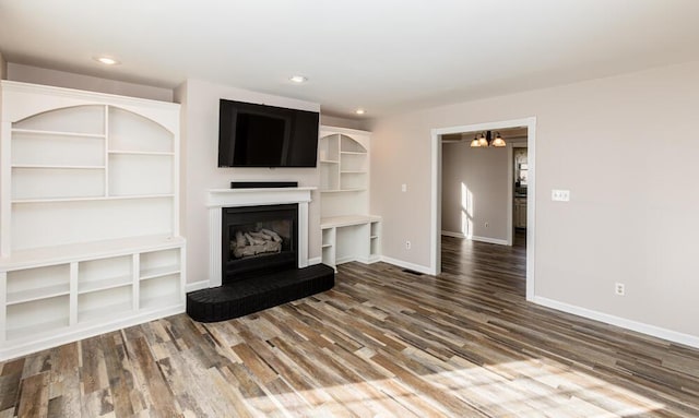 unfurnished living room featuring hardwood / wood-style flooring and a chandelier