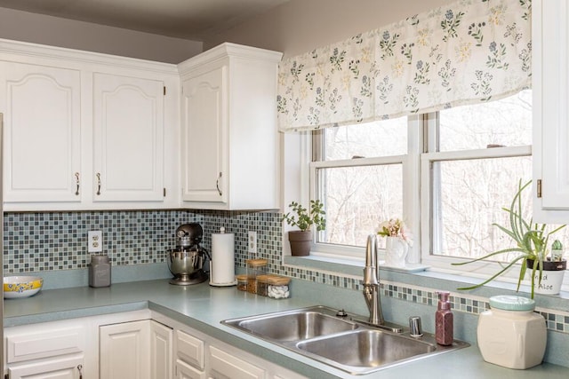 kitchen with white cabinets, backsplash, and sink