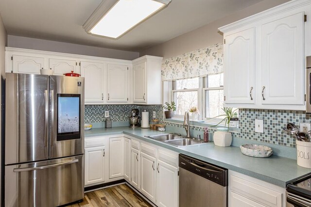 kitchen featuring white cabinets, decorative backsplash, sink, and stainless steel appliances