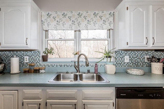 kitchen with decorative backsplash, stainless steel dishwasher, sink, white cabinetry, and plenty of natural light