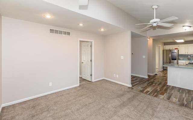 unfurnished living room with ceiling fan and dark carpet