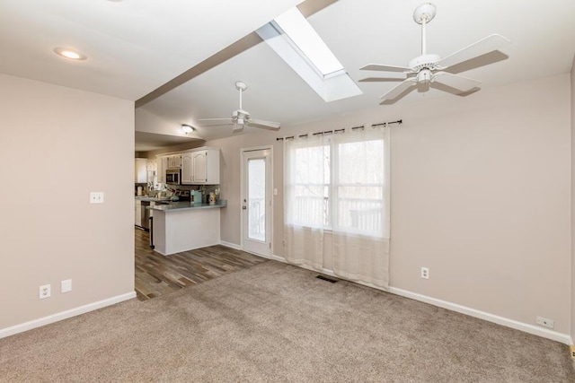 unfurnished living room featuring light carpet, vaulted ceiling, and ceiling fan