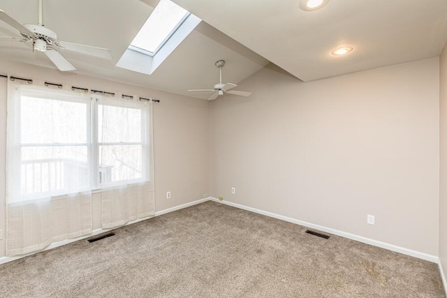 empty room with a wealth of natural light, ceiling fan, carpet, and vaulted ceiling