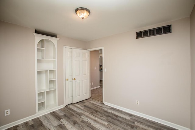 unfurnished bedroom with hardwood / wood-style flooring