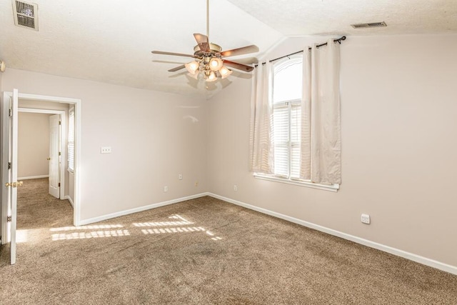 carpeted spare room with a textured ceiling, ceiling fan, and lofted ceiling