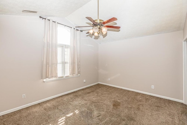 spare room with carpet flooring, a textured ceiling, vaulted ceiling, and ceiling fan