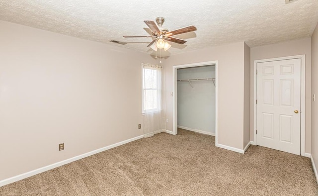 unfurnished bedroom featuring a textured ceiling, ceiling fan, light carpet, and a closet