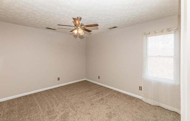 carpeted spare room featuring ceiling fan and a textured ceiling