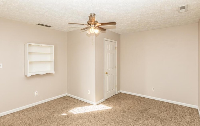 spare room with carpet flooring, a textured ceiling, and ceiling fan