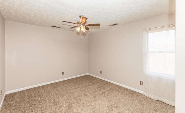 carpeted empty room with a wealth of natural light, ceiling fan, and a textured ceiling