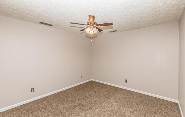 unfurnished room featuring ceiling fan, carpet floors, and a textured ceiling