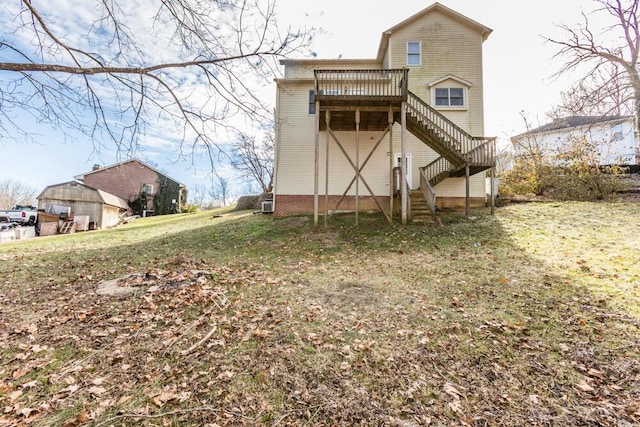 rear view of property featuring a wooden deck and a yard