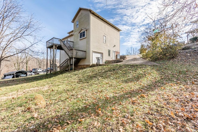 view of side of home featuring a lawn, a garage, and a deck