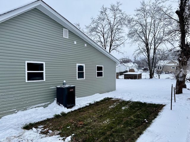 snow covered property featuring central AC unit