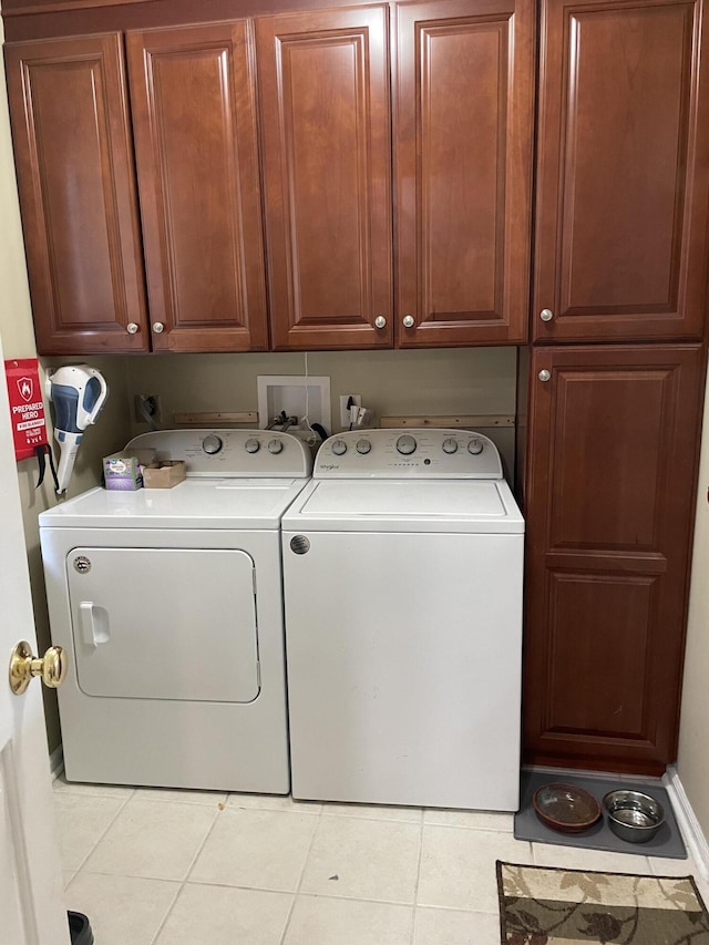 washroom with cabinets, light tile patterned floors, and separate washer and dryer