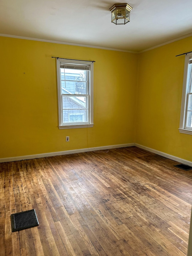 spare room with wood-type flooring and crown molding