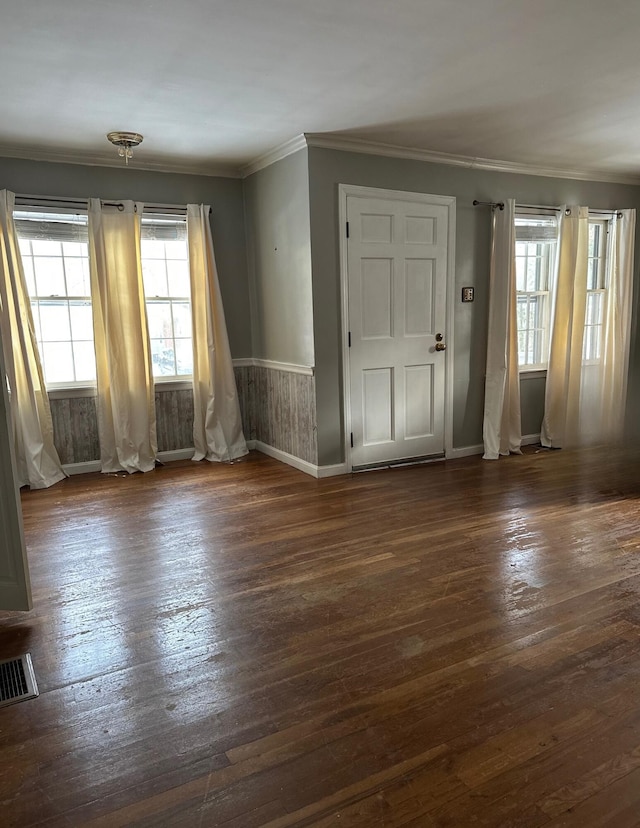 empty room featuring crown molding and dark wood-type flooring