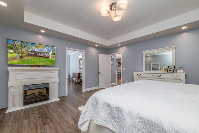 bedroom featuring a tray ceiling and dark wood-type flooring