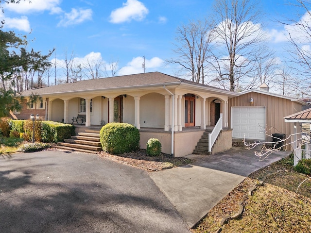 single story home featuring a porch and a garage