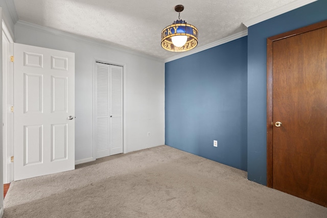 unfurnished bedroom with a textured ceiling, light colored carpet, and ornamental molding