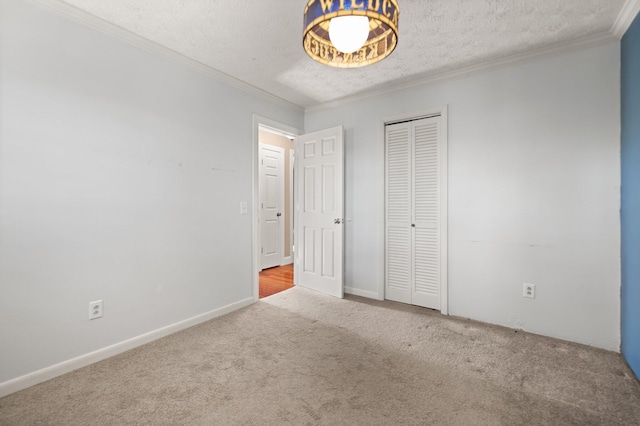 unfurnished bedroom with light colored carpet, a textured ceiling, and ornamental molding