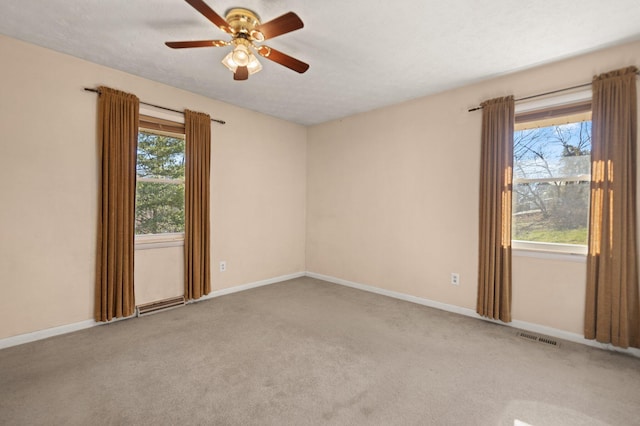 carpeted spare room featuring ceiling fan