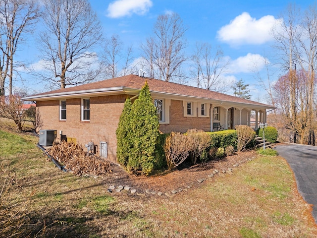 view of property exterior with covered porch and central AC