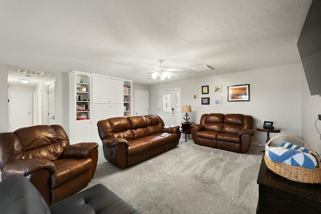 living room featuring ceiling fan, carpet, and a textured ceiling