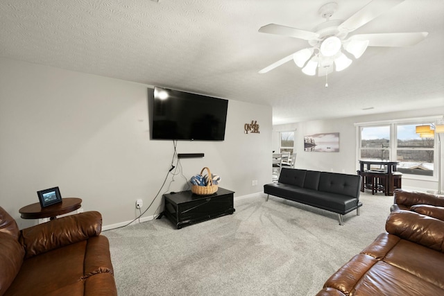 carpeted living room with ceiling fan and a textured ceiling