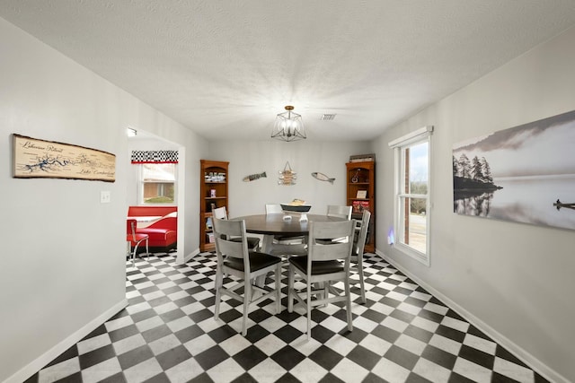 dining room with a notable chandelier and a textured ceiling